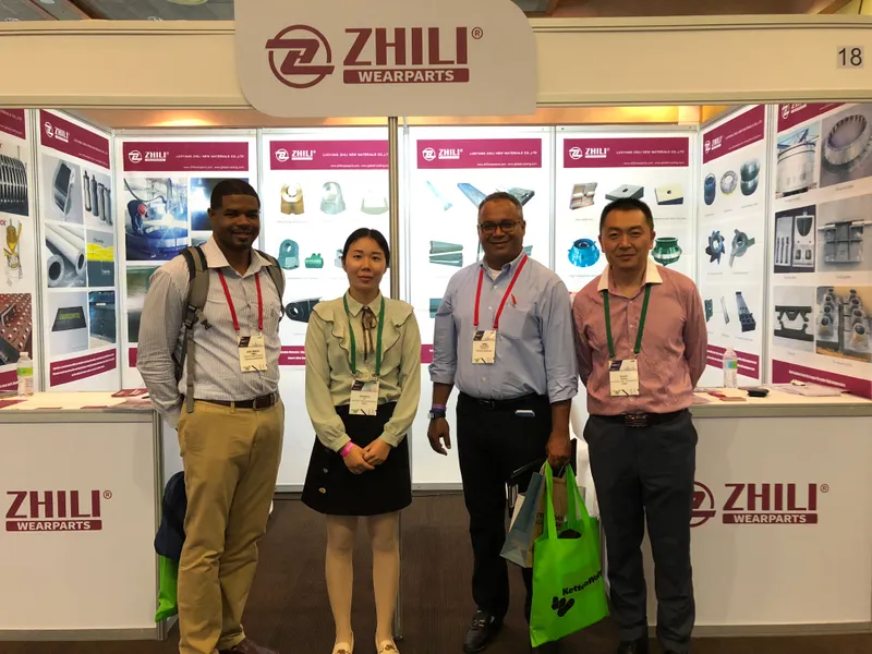 Équipe ZL Wearparts avec des acheteurs sur un stand présentant des composants de concasseurs et broyeurs